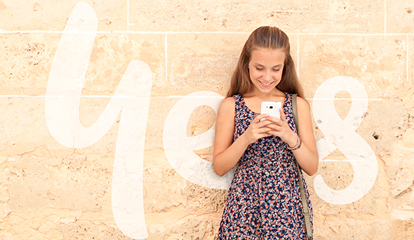 about-eval-2018 Happy young girl playing on her phone with Optus Yes logo in the background.