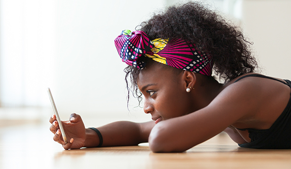 Young girl contently playing on her phone.
