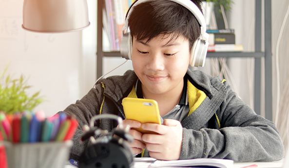 02blog-series Young boy contently playing on his phone.