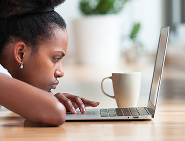 A young woman in deep focus on her laptop.