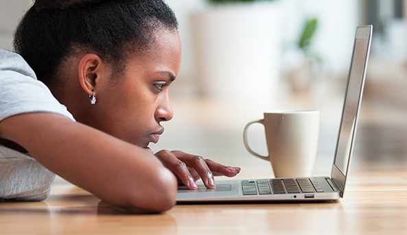 year9-593x343 A young woman in deep focus on her laptop.