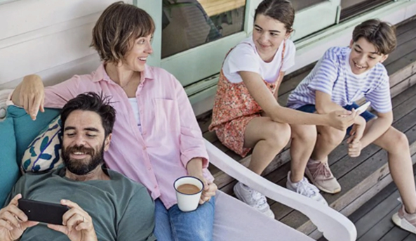 A family enjoying time together whilst watching their dad’s phone