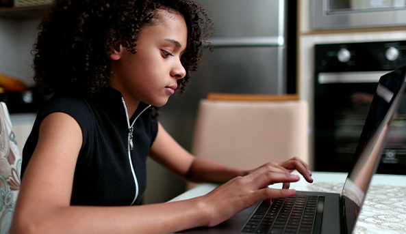 A young woman in deep focus on her laptop