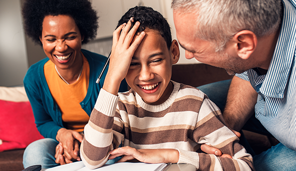 Young boy and his mother and father enjoying an activity on a notebook